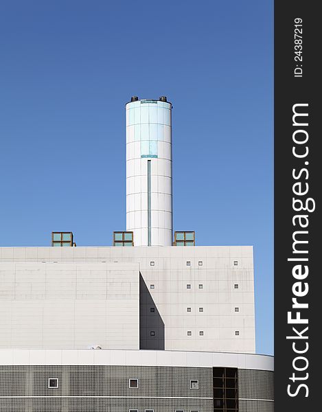 Incineration plant with chimney against blue sky