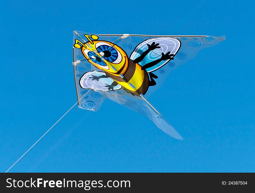 Cartoon bee character kite flying against a bright clear blue sky. Cartoon bee character kite flying against a bright clear blue sky.