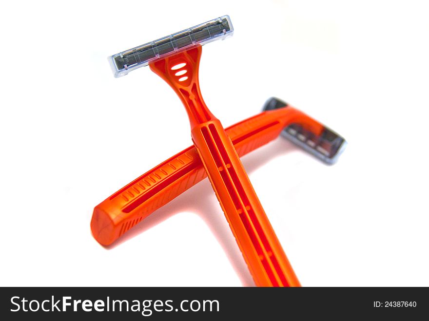 Two orange razor blades close-up on white background