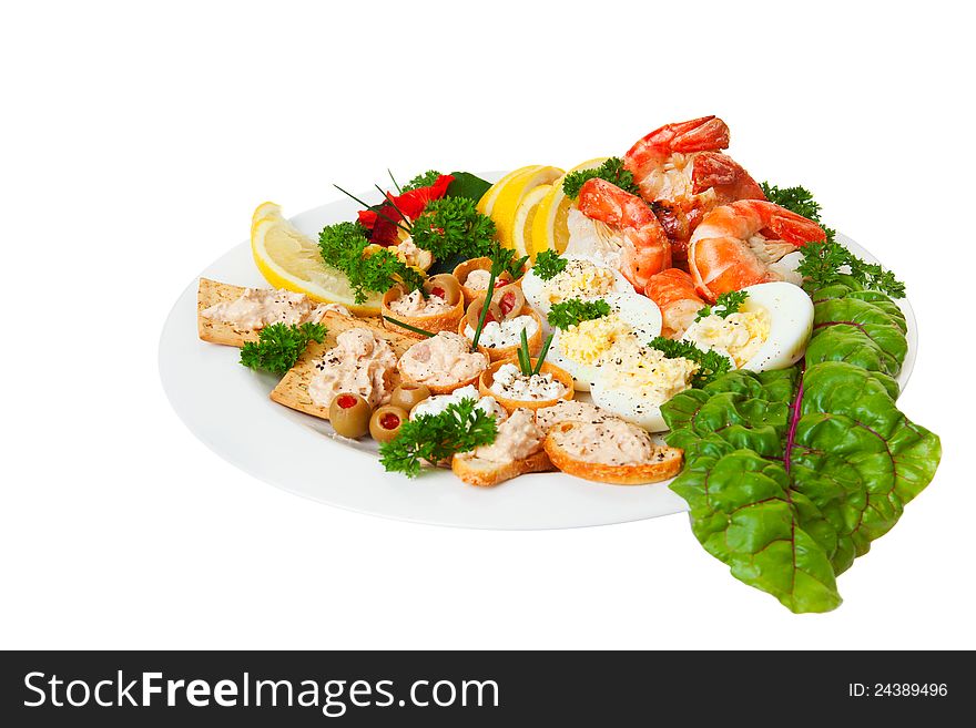 Plate full of orderves, edible flowers and shrimp isolated on a white background. Plate full of orderves, edible flowers and shrimp isolated on a white background