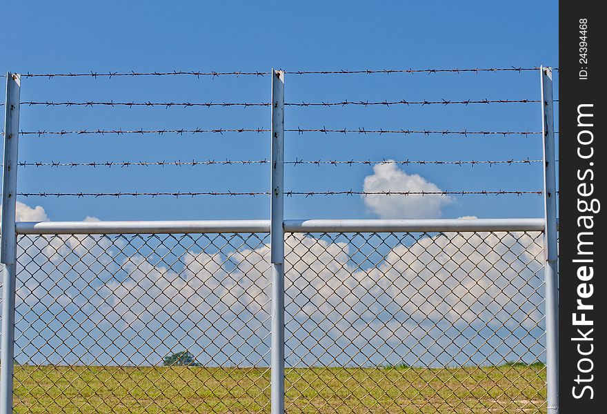 Barbed wire fence and blue sky. Barbed wire fence and blue sky.