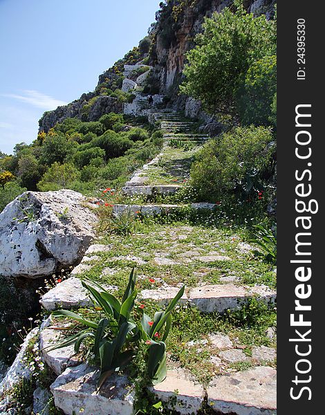 The small islands off the Greek island of Meis. Shows the overgrown steps that climb the hill to look over the harbour. The small islands off the Greek island of Meis. Shows the overgrown steps that climb the hill to look over the harbour