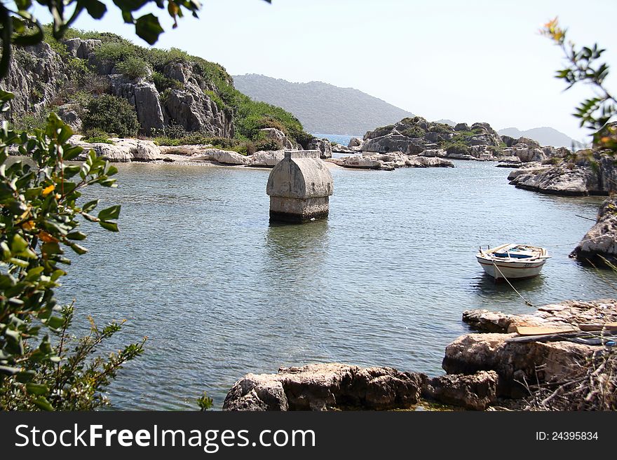 Taken on a walk along the Lycian way to Simena in Turkey. Shows a tomb surroundered by the sea with an old rowing boat in the foreground. Taken on a walk along the Lycian way to Simena in Turkey. Shows a tomb surroundered by the sea with an old rowing boat in the foreground