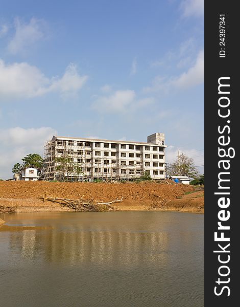 Building construction on land which has a reflection in the pond. Building construction on land which has a reflection in the pond.