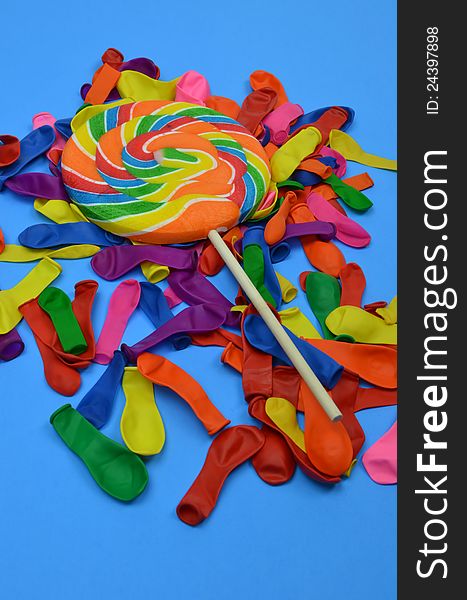 Bright Candy Lollipop With Ready To Inflate Balloons On Blue Background. Happy Birthday!. Bright Candy Lollipop With Ready To Inflate Balloons On Blue Background. Happy Birthday!