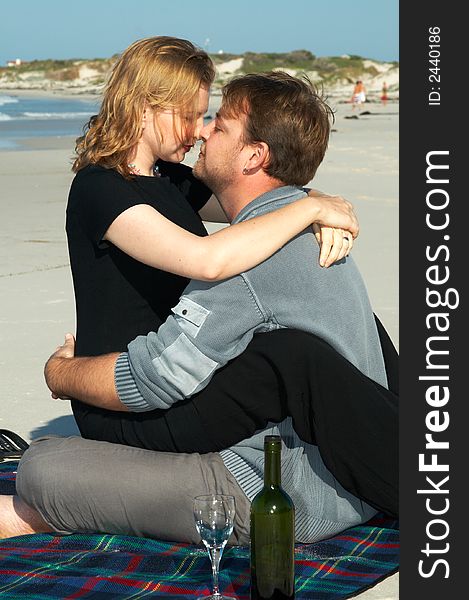 Young married couple looking lovingly into each other's eyes on white sandy beach in South Africa. Shot on a sunny day in winter.