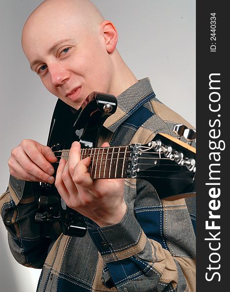 The musician with a guitar on a grey background