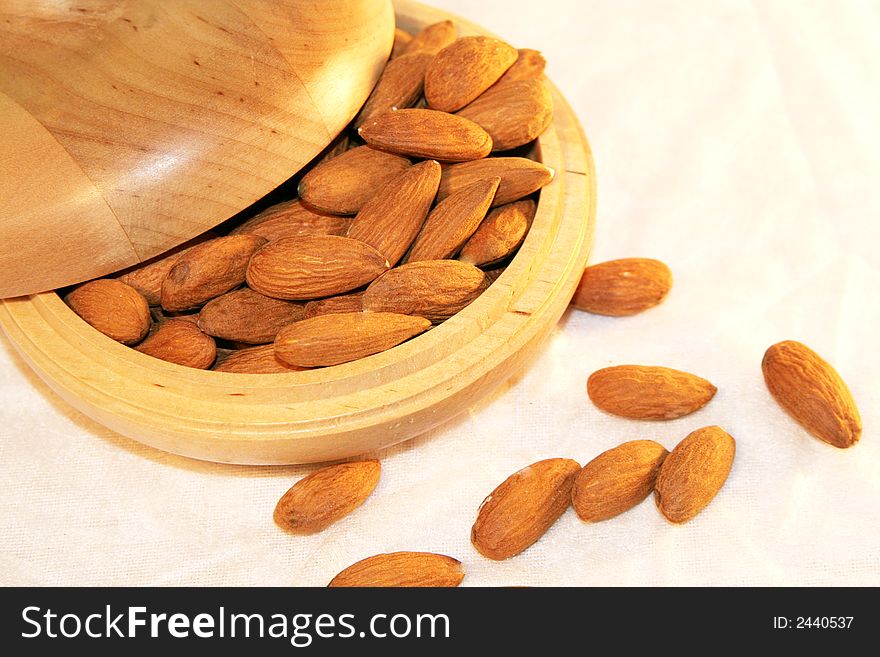 A heap of almonds in wooden container