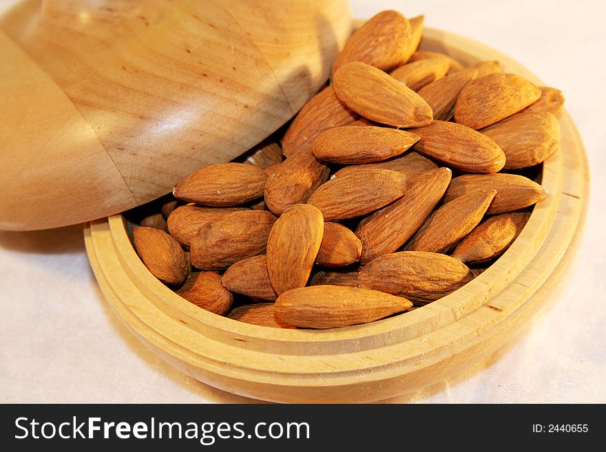 A heap of almonds in wooden container