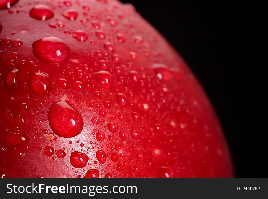 Close-up of red apple with water drops; black background. Close-up of red apple with water drops; black background