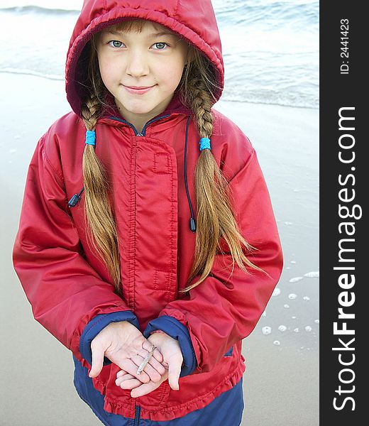 The girl holds a small fish in hands. The girl holds a small fish in hands