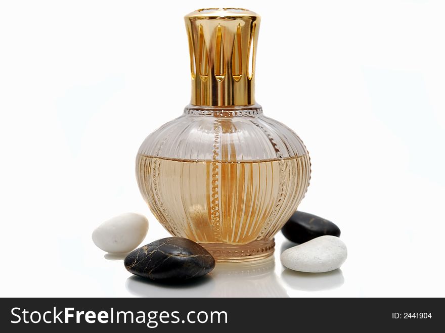 Gold perfume bottle and stone on the white background. Gold perfume bottle and stone on the white background