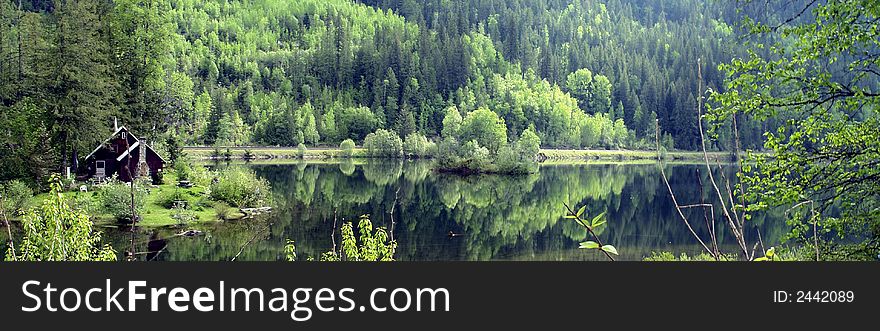 Rustic cabin and spring foliage at Three Valley Lake south of Revelstoke, British Columbia. Rustic cabin and spring foliage at Three Valley Lake south of Revelstoke, British Columbia