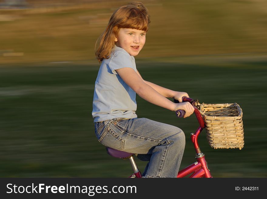 Girl riding bike in the park, motion blur background. Girl riding bike in the park, motion blur background