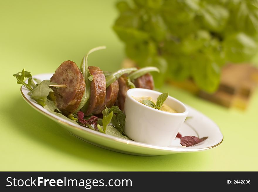 Sausage with salad on the green background