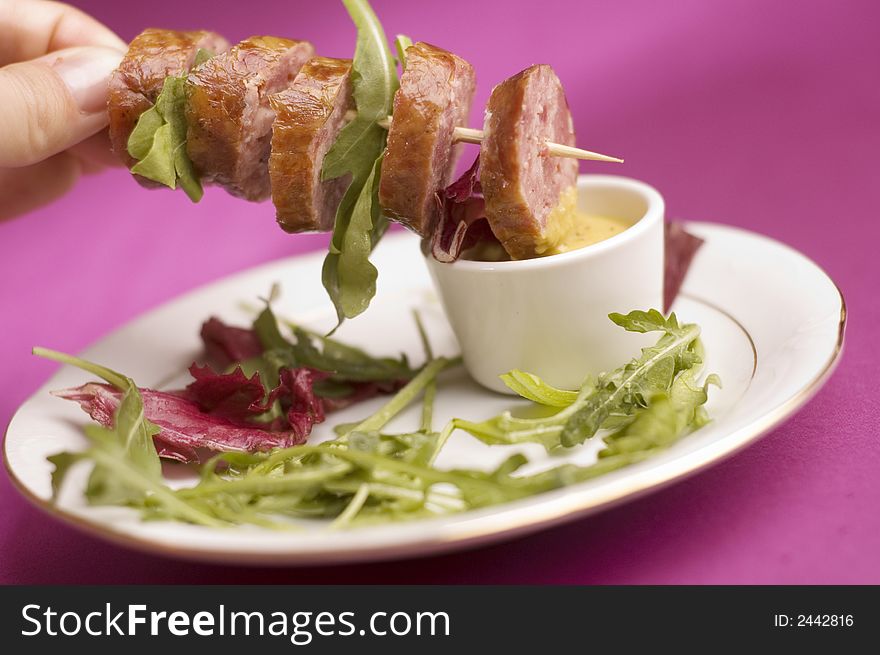 Sausage with salad on the pink background