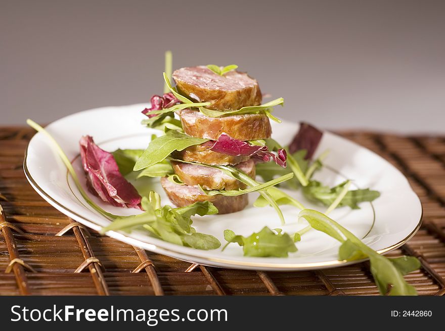 Sausage with salad on the natural background