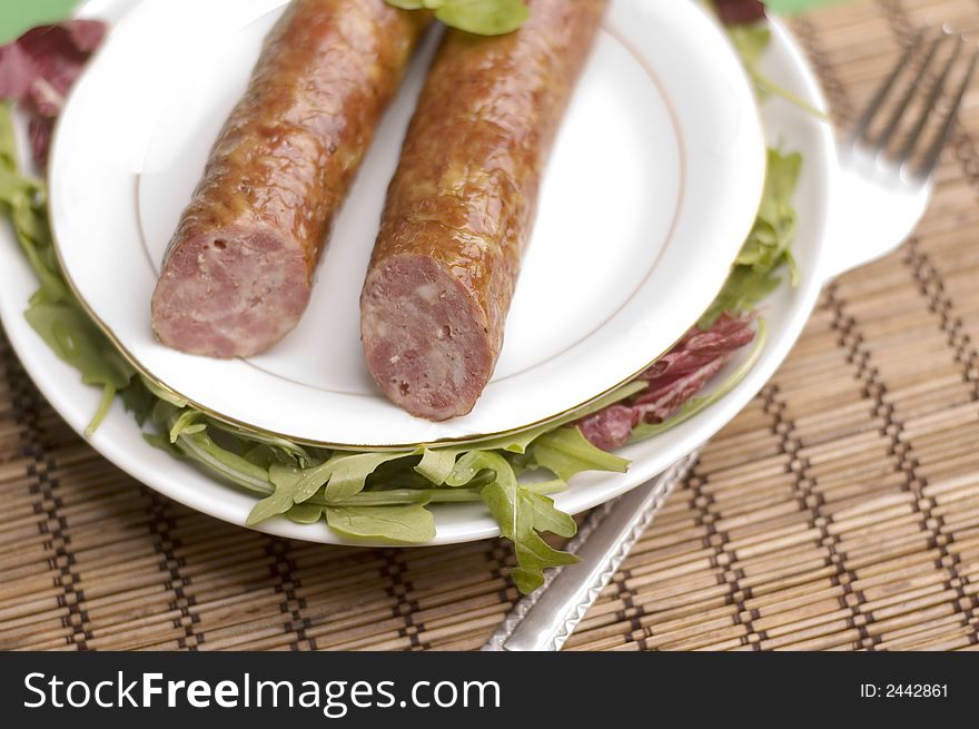 Sausage with salad on the natural background