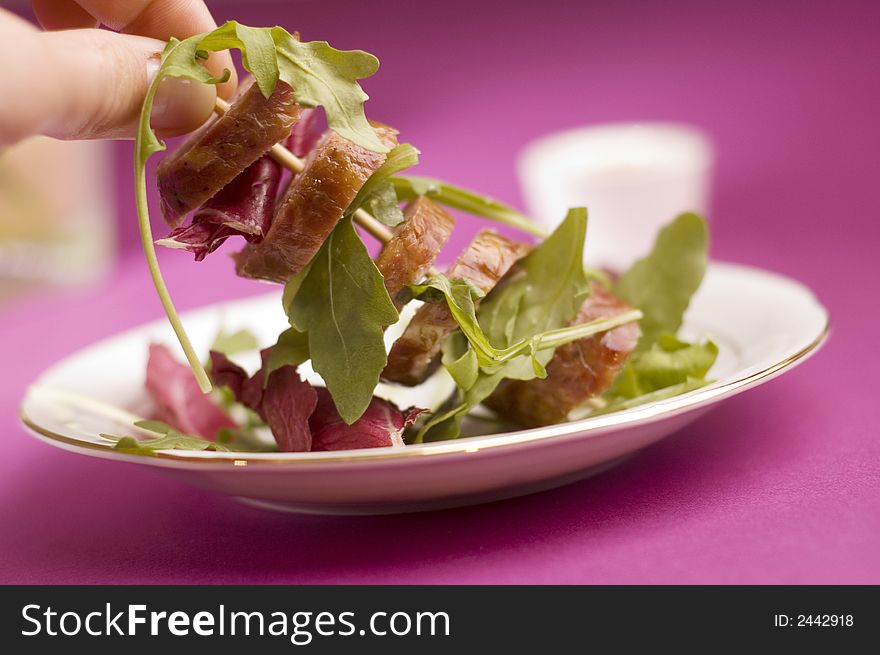 Sausage with salad on the pink background