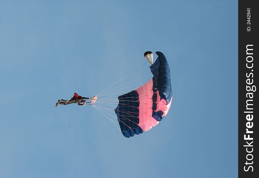 The parachuter on a background of the blue sky