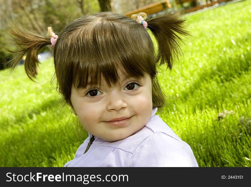 Little happy girl sitting on grass. Little happy girl sitting on grass