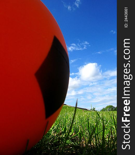 Orange ball with pentagon sign on the grass playing field

background clouds and blue sky. Orange ball with pentagon sign on the grass playing field

background clouds and blue sky