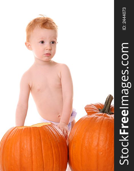 Redheaded boy sitting in pumpkins. Redheaded boy sitting in pumpkins