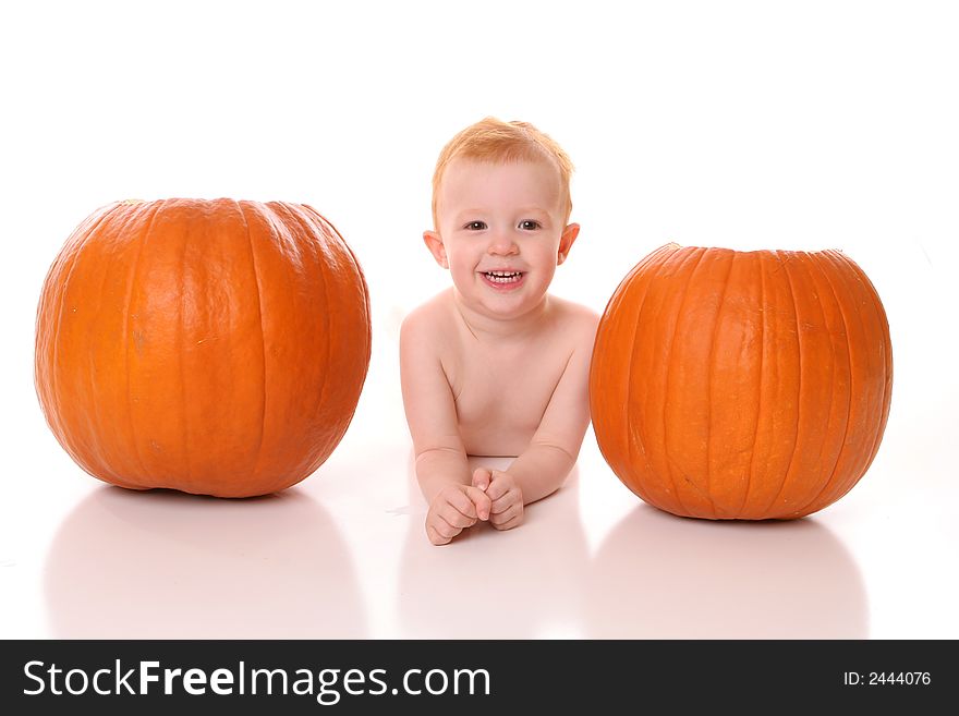 Redhead boy laying between pumpkins. Redhead boy laying between pumpkins