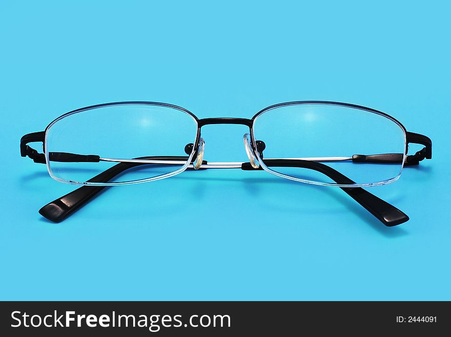 Eyeglasses on a blue background with smooth shadow. Eyeglasses on a blue background with smooth shadow