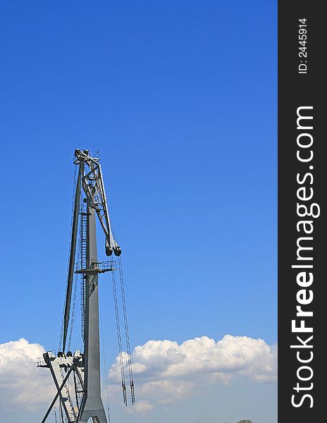 The port crane on a background of the blue sky.