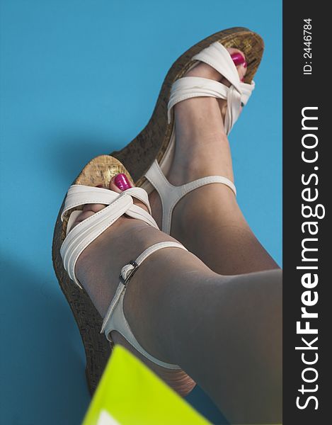 Close up of feet in white shoes over blue background. Close up of feet in white shoes over blue background