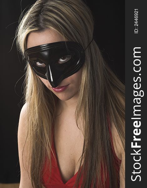 Young woman wearing a black mask over black drop