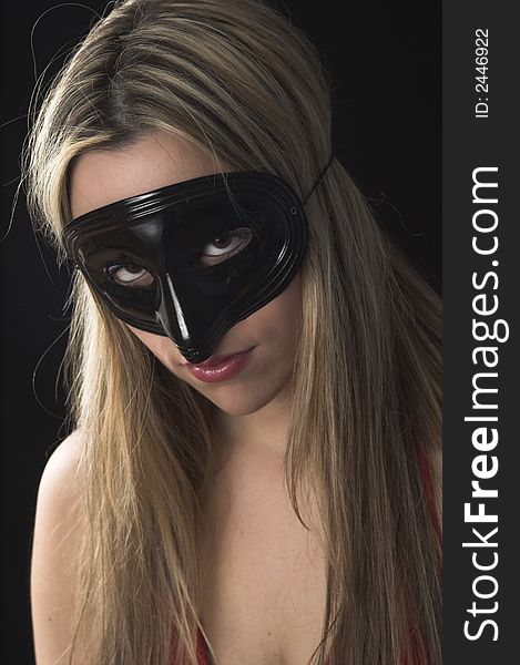 Young woman wearing a black mask over black drop