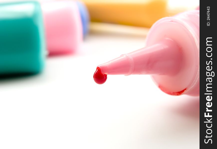 Tube of a red paint with red drop on white background