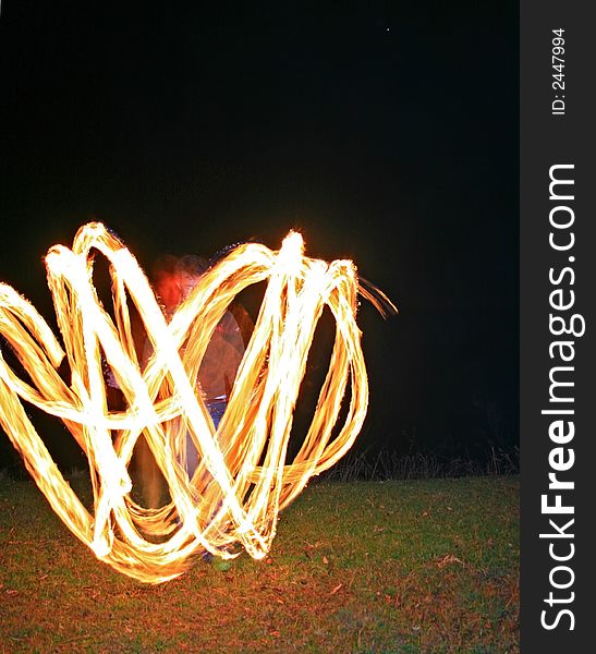 A fire dancer with fire trails creating beautiful effect