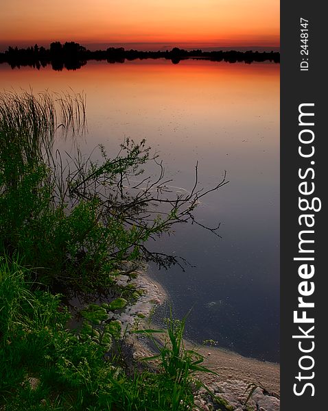 A calm lake after sunset. A calm lake after sunset