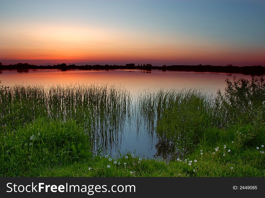 A calm lake after sunset. A calm lake after sunset