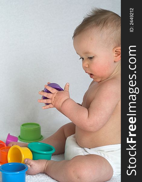 Image of an adorable baby playing with colorful stacking cups. Image of an adorable baby playing with colorful stacking cups