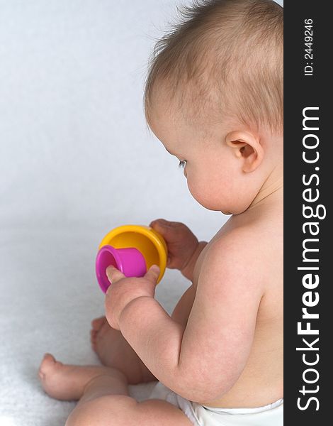 Image of an adorable baby playing with colorful stacking cups. Image of an adorable baby playing with colorful stacking cups