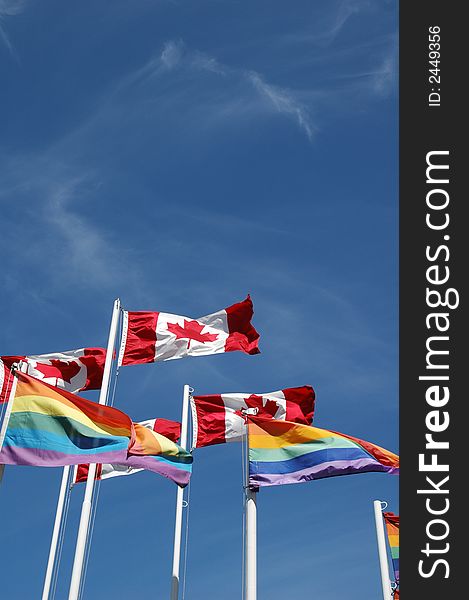 Canadian and gay pride flags fly together over English Bay, Vancouver, British Columbia, Canada. Canadian and gay pride flags fly together over English Bay, Vancouver, British Columbia, Canada