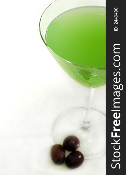 A summery green cocktail with some grapes on a white background. A summery green cocktail with some grapes on a white background.