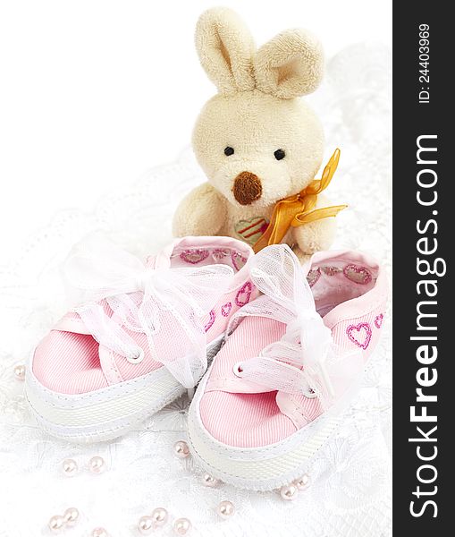 Pair of pink  Babies shoes with toy and pearls. Pair of pink  Babies shoes with toy and pearls