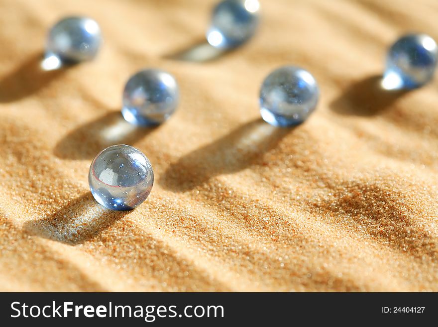 Abstract composition with few blue glass balls on sand surface. Abstract composition with few blue glass balls on sand surface