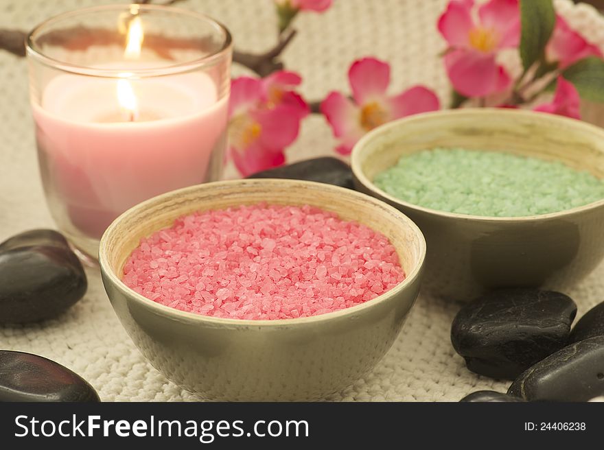 Relaxing green and pink bath salt wiht a candle and black stones.