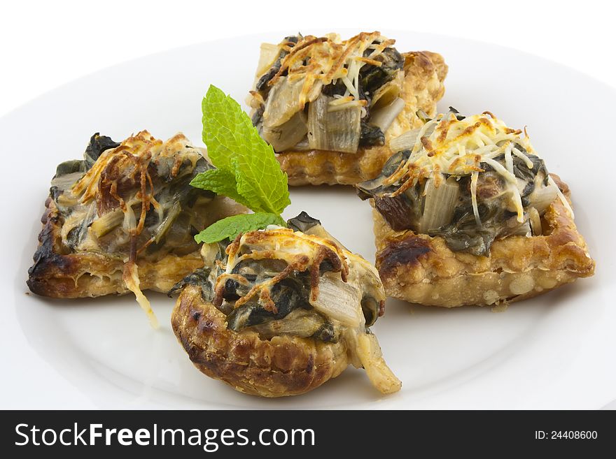 Vegetable baked cakes of pastry with chard, tomato and cheese. Homemade and decorated with mint