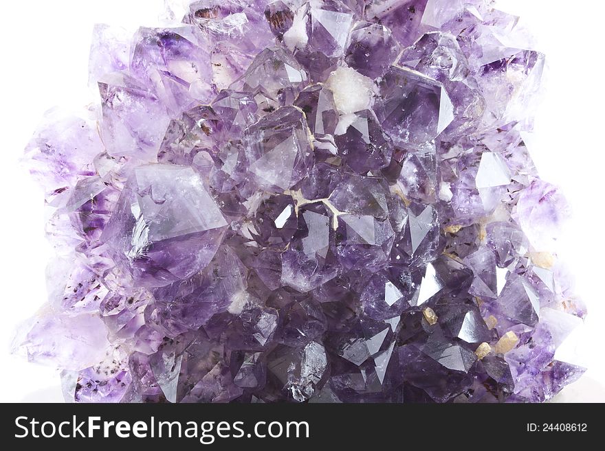 Natural amethyst geode with growing crystal structure and extending from the rock