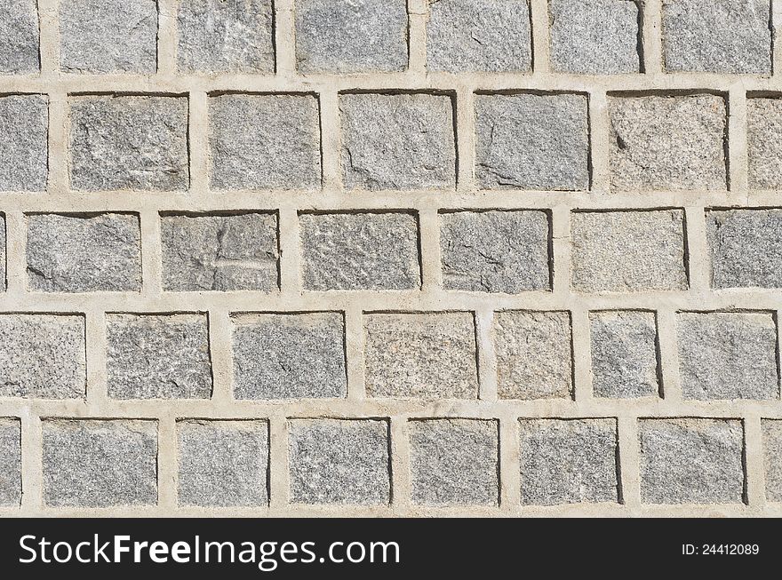 Gray granite stone wall pattern with thick concrete border