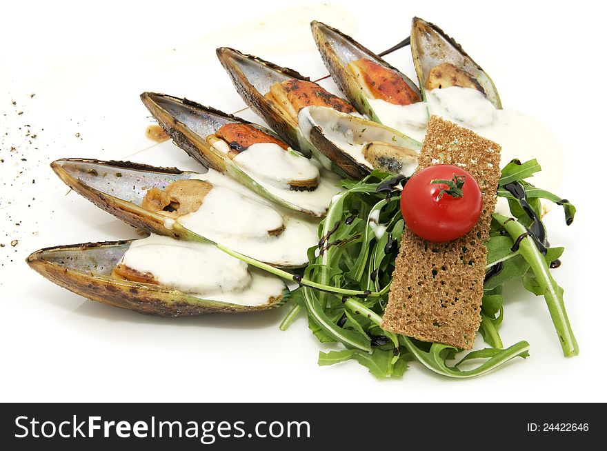 Mussels with sauce and greens on a white background