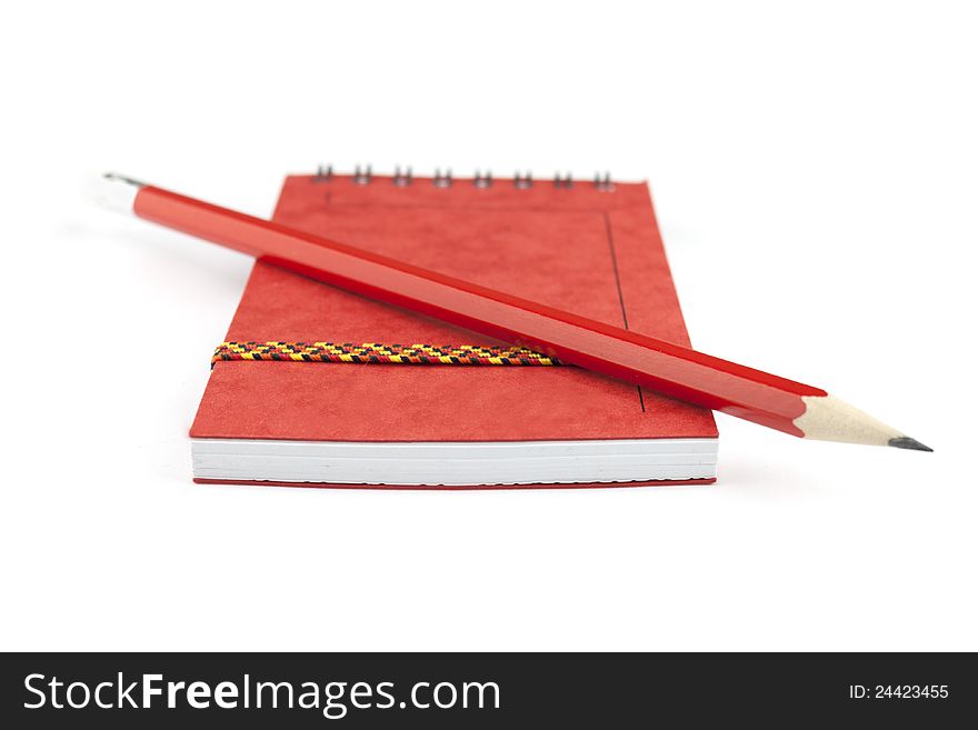 Red closed notepad and pencil isolated on white
