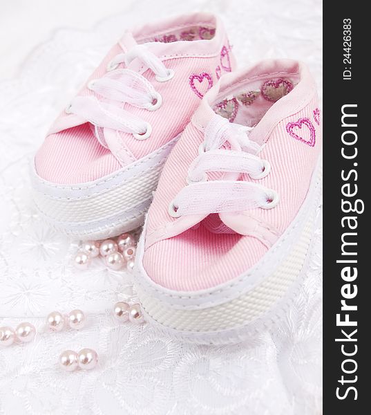 Pair of pink Babies shoes with pearls. Pair of pink Babies shoes with pearls